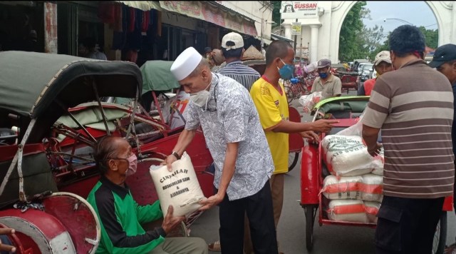 Tokoh masyarakat Solo, Habib HM terlihat dalam kegiatan berbagi beras dan uang untuk diberikan kepada sejumlah pengayuh becak di kawasan Pasar Klewer, Solo