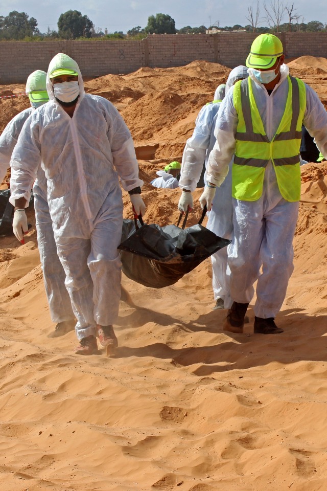 Petugas membawa jenazah yang ditemukan di kuburan massal, di kota Tarhouna, Libya, (27/10). Foto: Ayman Al-Sahili/REUTERS