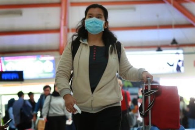 Penumpang pesawat mengenakan masker saat di bandara Abdul Rachman Saleh, Malang. Foto: Bayu Eka