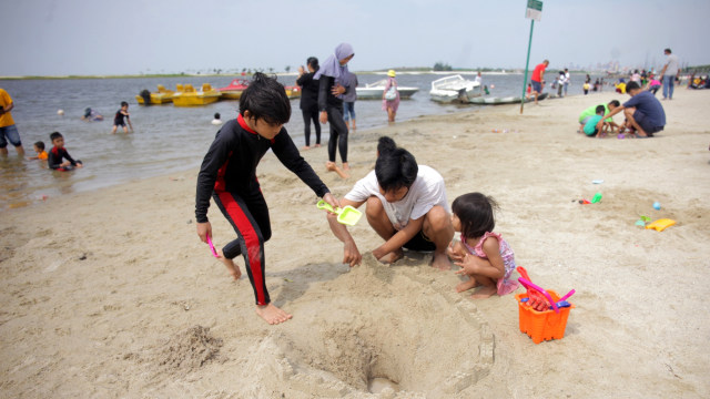 Wisatawan menikmati suasana Pantai Lagoon, Ancol, Jakarta, Kamis (29/10). Foto: Reno Esnir/ANTARA FOTO