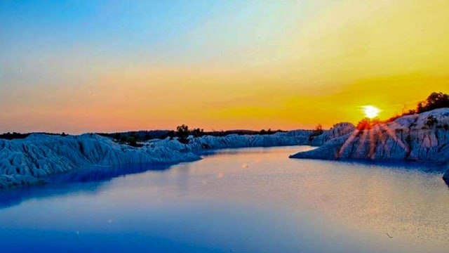 Pemandangan senja yang menawan dan birunya air Danau Kaolin