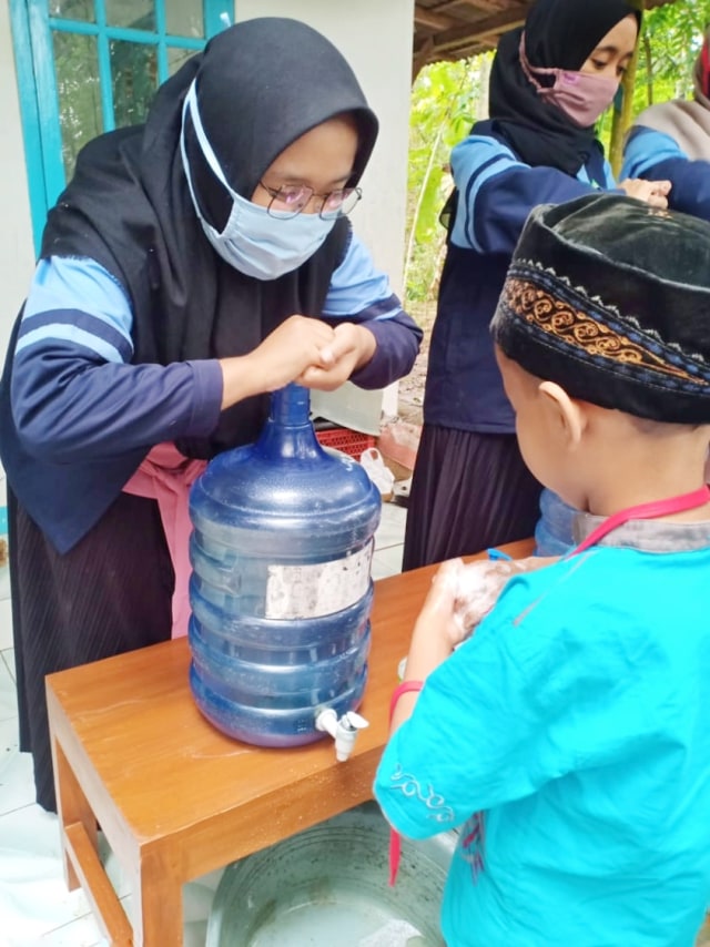 Murid TPQ Al Amin Desa Karangmangu praktik mencuci tangan didampingi oleh mahasiswa KKN DR 75 kelompok 122