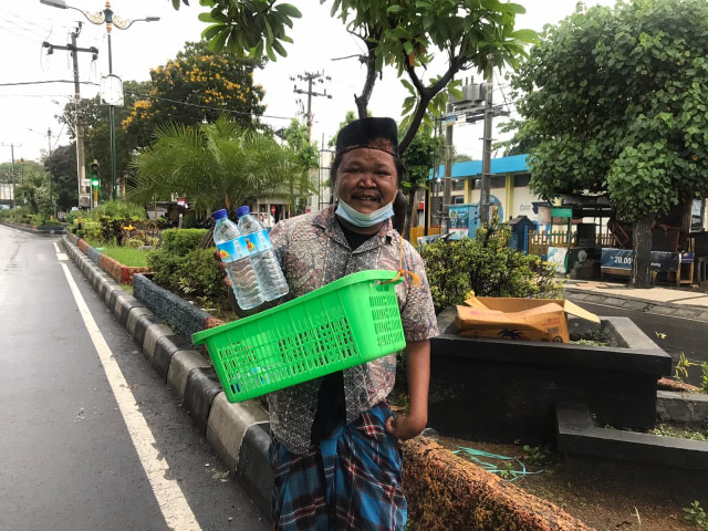 Foto pak Lan saat berjualan air mineral, Kamis (29/10)