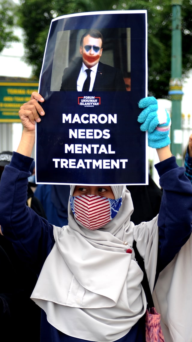 Pengunjuk rasa menunjukkan poster saat demonstrasi menentang Presiden Prancis Emmanuel Macron, di Yogyakarta, Jumat (30/10). Foto: AGUNG SUPRIYANTO/AFP