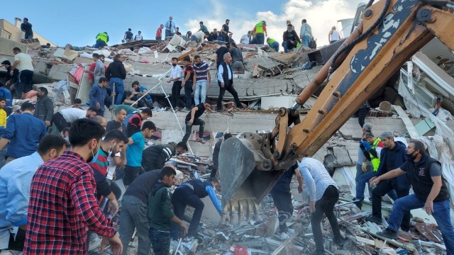 Warga dan petugas mencari korban selamat di sebuah bangunan yang runtuh setelah gempa bumi, di provinsi pesisir Izmir, Turki, Jumat (30/10). Foto: Tuncay Dersinlioglu/REUTERS