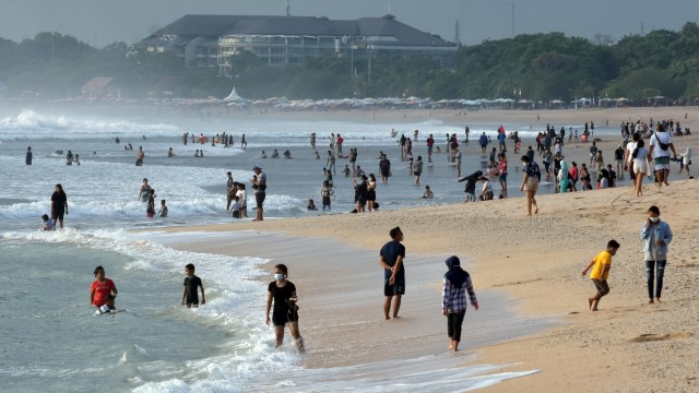 Wisatawan berlibur pada liburan panjang Hari Maulid Nabi Muhammad SAW di Pantai Kuta, Badung, Bali, Jumat (30/10). Foto: Nyoman Hendra Wibowo/ANTARA FOTO