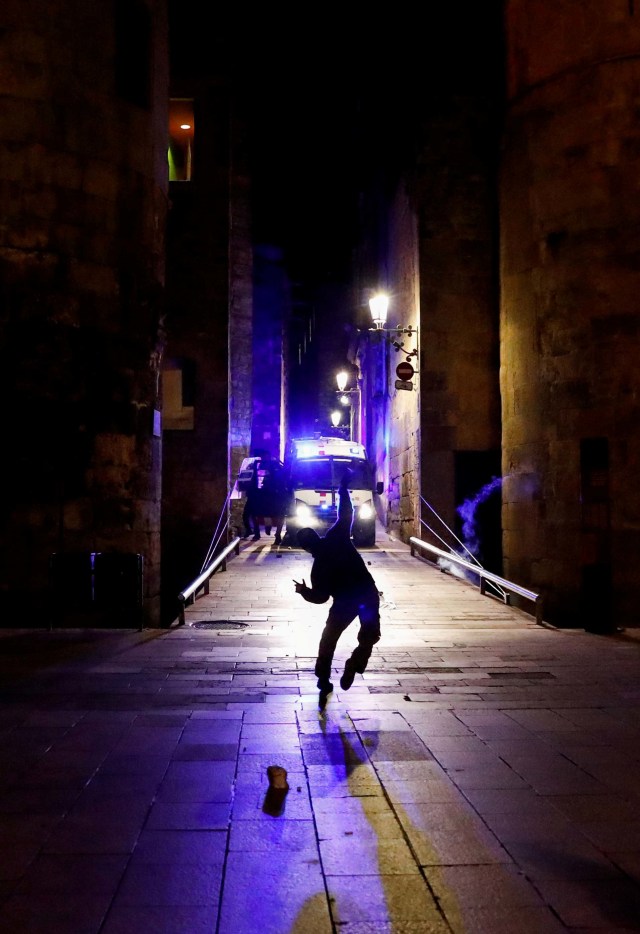 Demonstran melempari batu ke arah polisi saat protes terhadap penutupan bar dan gym di Barcelona, Spanyol. Foto: Nacho Doce/Reuters