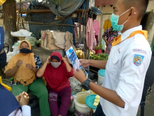 Relawan dari Forum Remaja Palang Merah Indonesia (Forpis) Kabupaten Tegal mengedukasi masyarakat tentang bahaya COVID -19, Sabtu (31/10/2020). (Foto: Dok. PMI)