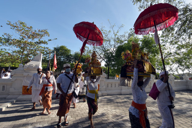 Umat Hindu dengan jumlah yang terbatas saat beriringan dalam upacara menjelang Hari Raya Kuningan di Pura Sakenan, Denpasar. Foto: Nyoman Hendra Wibowo/ANTARA FOTO