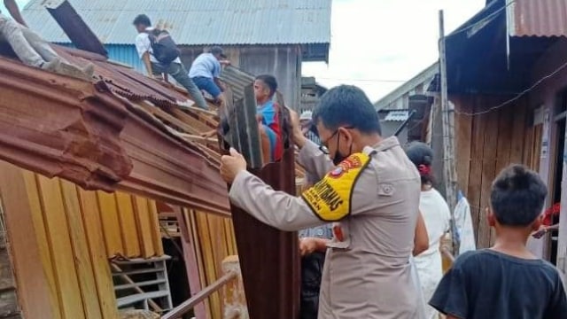Tampak sejumlah warga dibantu personel Polsek Baolan mengeluarkan isi rumah akibat roboh secara mendadak, Senin (2/11). Foto: Istimewa