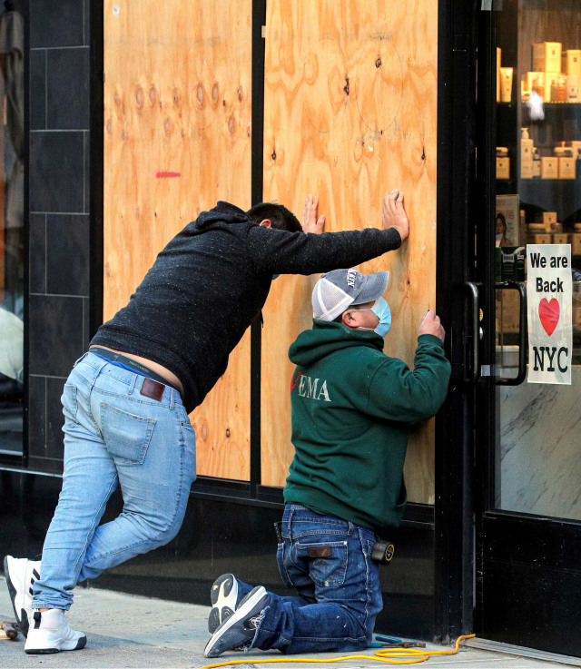 Suasana saat para pekerja menutup toko dengan papan untuk mengantisipasi kerusuhan usai pemilu di Manhattan, New York, Amerika Serikat. Foto: Brendan McDermid /Reuters