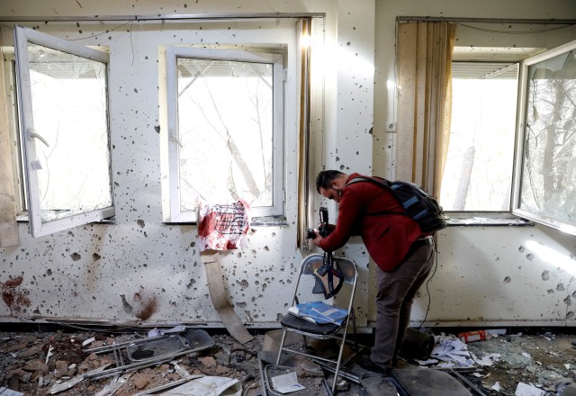 Jurnalis Afghanistan meliput di dalam ruangan yang rusak setelah serangan di Universitas Kabul, Afghanistan, Selasa (3/11). Foto: Mohammad Ismail/Reuters