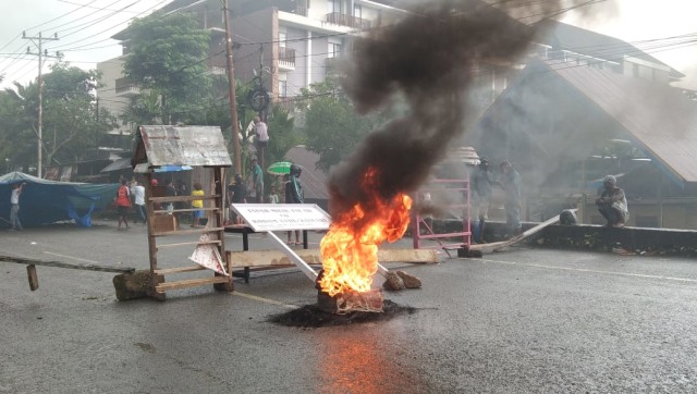 Warga melakukan aksi bakar ban agar Pemerintah Daerah merespon tuntutan mereka, foto : Yanti
