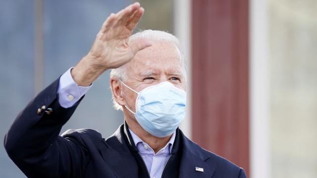 Calon presiden dari Partai Demokrat AS Joe Biden menyapa pendukungnya tiba di sebuah restoran, pada Hari Pemilihan di Philadelphia, Pennsylvania, AS, Selasa (3/11). Foto: KEVIN LAMARQUE/REUTERS
