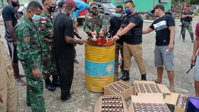 Pemusnahan minuman keras hasil temuan di Jalan Trans Papua. (Dok Polda Papua)