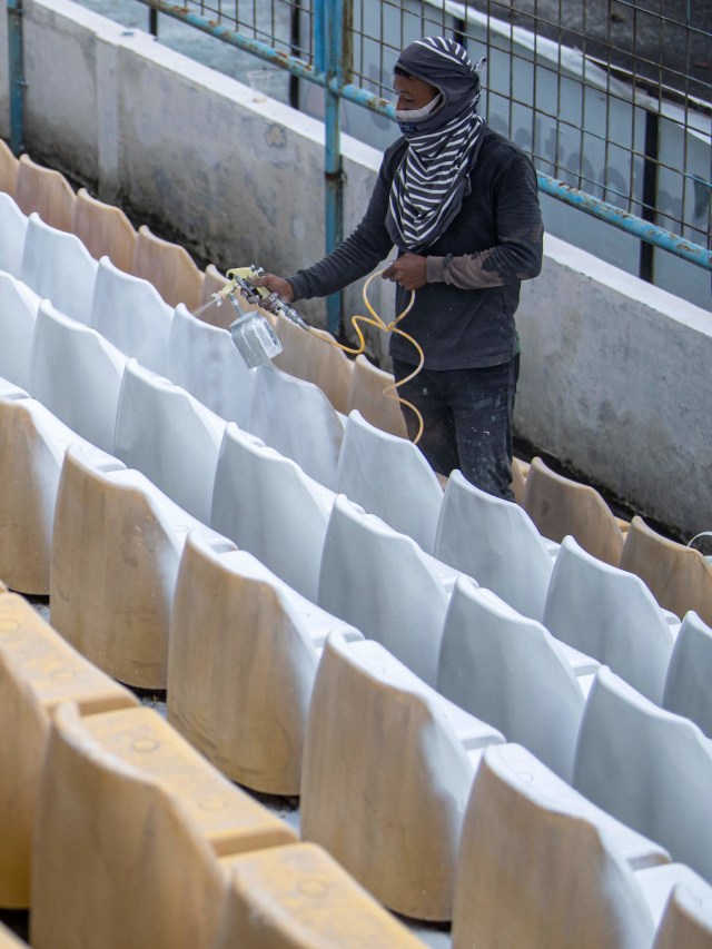 Pekerja mengecat kursi penonton Stadion Madya Bumi Sriwijaya Palembang, di Sumatera Selatan, Kamis (5/11). Foto: Nova Wahyudi/Antara Foto