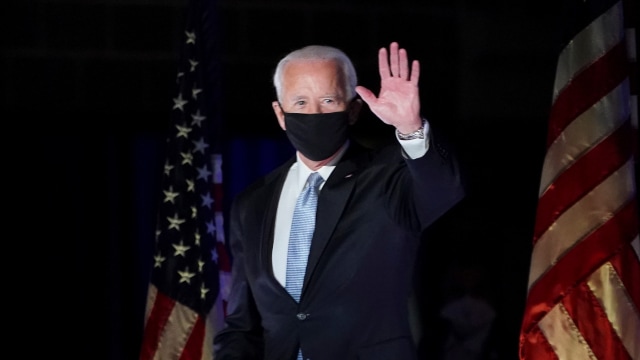 Joe Biden menyapa pendukungnya saat berada di atas panggung pidato di Wilmington, Delaware, pada Sabtu (7/11) malam waktu setempat sekitar pukul 20.00 atau pukul 08.00 WIB. Foto: KEVIN LAMARQUE/REUTERS