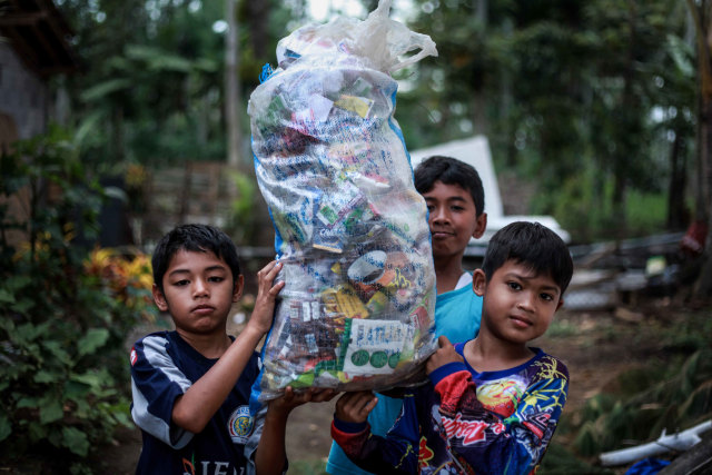 Anak-anak membawa sampah. Foto: Ben
