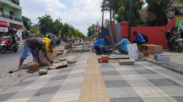 Situasi para pekerja yang sedang mengerjakan pemasangan ubin trotoar di Jalan Panglima Sudirman Kota Bojonegoro. Selasa (10/11/2020)