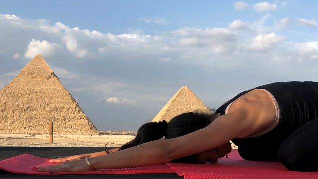 Seorang perempuan menghadiri acara Yes Yoga Day untuk mendukung pemberantasan kekerasan terhadap perempuan di tengah pandemi COVID-19 di depan piramida bersejarah Giza, Mesir. Foto: AHMED FAHMY/REUTERS