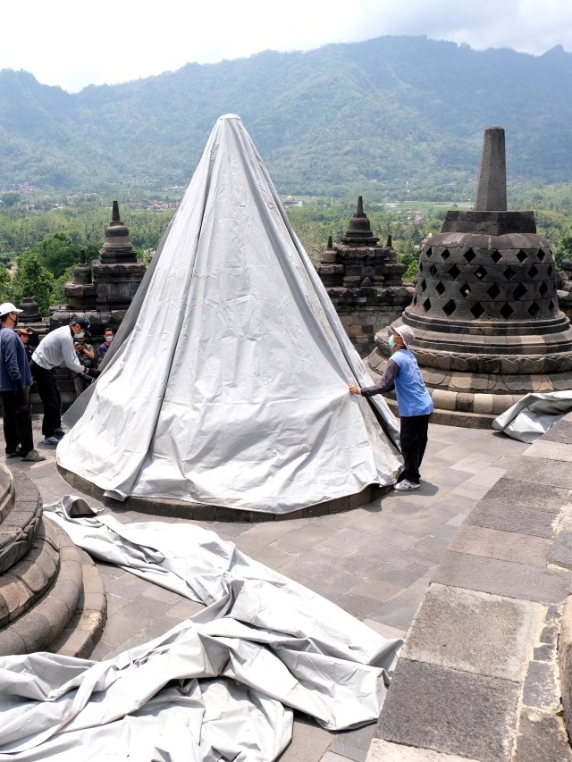 Sejumlah pekerja menutup stupa menggunakan terpaulin di kompleks candi Borobudur, Magelang, Jateng, Rabu (11/11). Foto: Anis Efizudin/Antara Foto