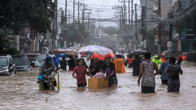 Warga mengevakuasi diri melintasi banjir akibat Topan Vamco menghantam ibu kota Filipina, di Marikina, Metro Manila, Filipina, Kamis (12/11). Foto: Eloisa Lopez/REUTERS