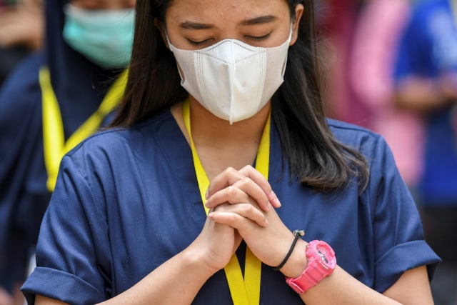 Seorang tenaga kesehatan berdoa saat memperingati Hari Kesehatan Nasional (HKN) ke-56 di Rumah Sakit Darurat COVID-19 Wisma Atlet Kemayoran di Jakarta, Kamis (12/11). Foto: M Risyal Hidayat/ANTARA FOTO