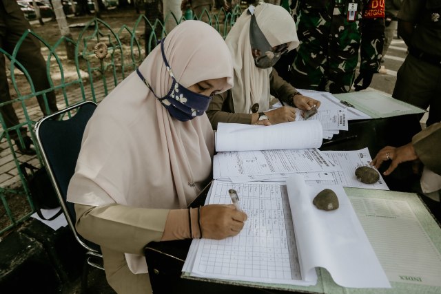 Petugas gabungan di Aceh saat mencatat nama warga yang terjaring razia protokol kesehatan. Foto: Abdul Hadi/acehkini