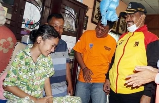 Nabila terlihat tersenyum saat ditemui Plt Wali Kota Pariaman Mardison Mahyuddin di rumahnya. Foto: ist