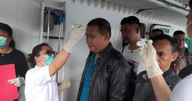 Pemeriksaan suhu tubuh di Pelabuhan Ulu Siau saat para penumpang hendak meninggal kapal