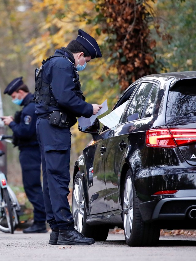 Polisi Prancis menghentikan mobil untuk memeriksa dokumen pengecualian dan identitas saat lockdown di daerah Bois de Boulogne, di Paris, Prancis. Foto: Christian Hartmann/Reuters