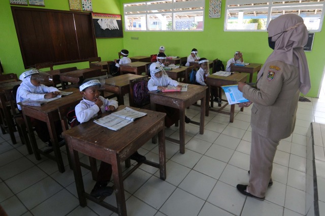 Seorang guru memberikan arahan kepada siswa saat pengumpulan tugas di SD Negeri 2 Tlogolele, Tlogolele, Selo, Boyolali, Jawa Tengah. Foto: Aloysius Jarot Nugroho/Antara Foto