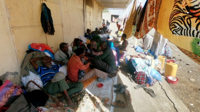 Warga Ethiopia yang melarikan diri dari pertempuran yang sedang berlangsung di wilayah Tigray duduk dengan barang-barang mereka di desa Hamdait di perbatasan Sudan-Ethiopia di negara bagian Kassala timur, Sudan, (14/11). Foto: El Tayeb Siddig/REUTERS