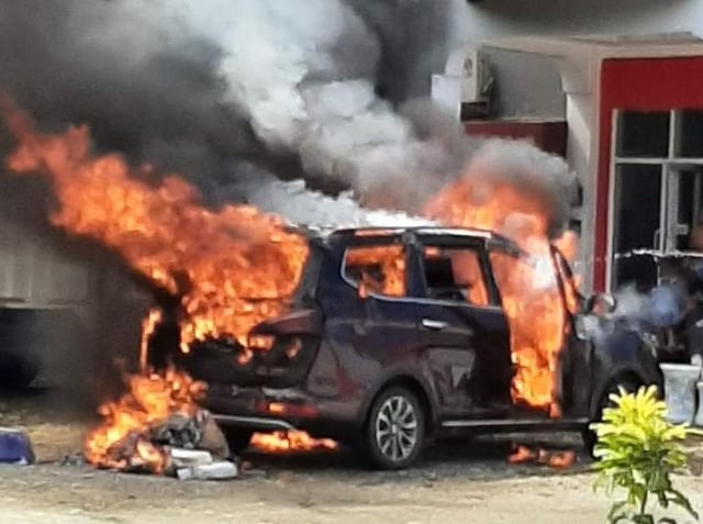 Sebuah mobil minu bus yang sedang terparkir terbakar di depan hotel di Kolaka Utara. Foto: Lukman Budianto/kendarinesia.