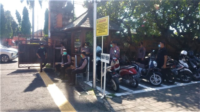 Polisi tampak berjaga di belakang pintu utama PN Denpasar = WIB