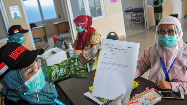 Petugas medis memberikan surat vaksinasi COVID-19 kepada warga saat simulasi di Puskesmas Cikarang, Kabupaten Bekasi, Jawa Barat, Kamis (19/11). Foto: Fakhri Hermansyah/ANTARA FOTO