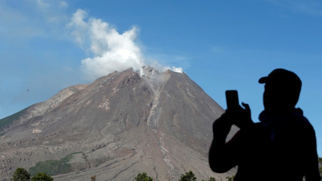 Wisatawan mengabadikan Gunung Sinabung dengan kamera gawainya di Kabupaten Karo, Sumatera Utara, Kamis (19/11). Foto: Irwansyah Putra/ANTARA FOTO