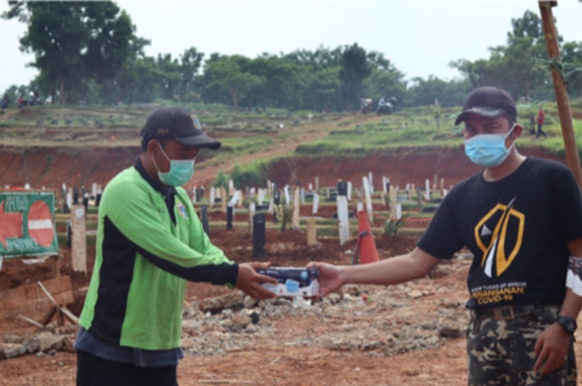 Bagikan Masker Medis - GP Ansor & Aice Group mendistribusikan masker medis 3-ply ke masyarakat bawah yang rentan tertular virus Covid-19. Salah satunya bagi para penggali kubur di Taman Pemakaman Umum Covid-19 Pondok Ranggon, Jakarta, Sabtu (14/11)