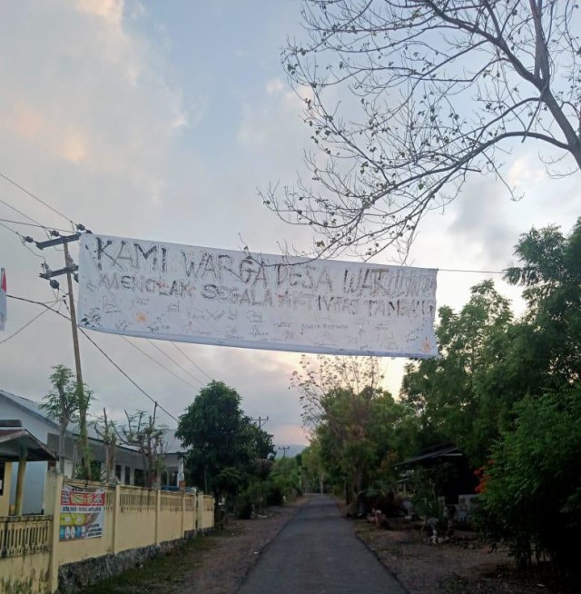 Spanduk penolakan terhadap aktivitas pengambilan batu di wilayah Desa Watuliwung yang dipasang di Depan Kantor Desa Watuliwung. Foto : Istimewa