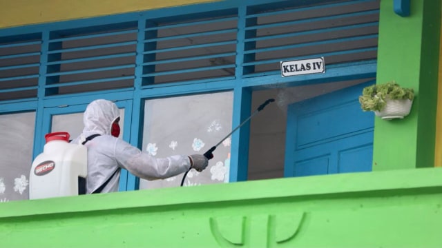 Petugas melakukan penyemprotan disinfektan di SD Negeri 37 Kota Banda Aceh, Kamis (19/11). Foto: Suparta/acehkini