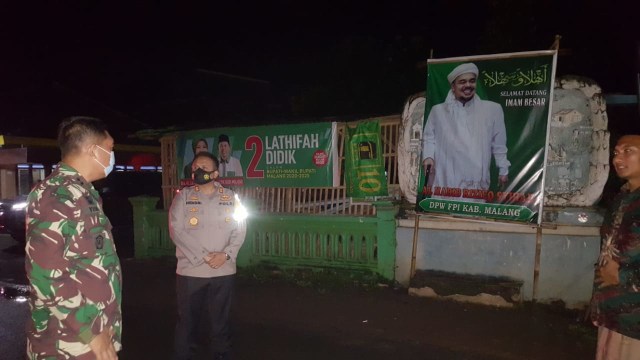 Penurunan baliho bergambar Habib Rizieq Shihab di Desa Ganjaran, Kecamatan Gondanglegi, Kabupaten Malang. Foto: Rizal Adhi