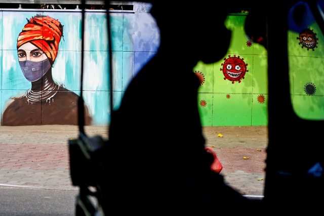 Mural bergambar ajakan menggunakan masker di New Delhi, India. Foto: Sajjad Hussain/AFP