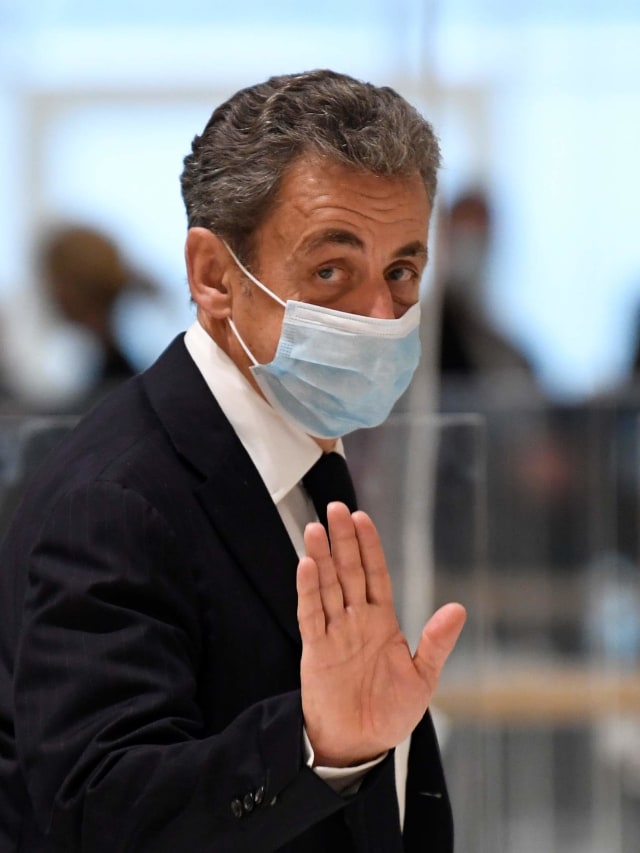 Mantan presiden Prancis Nicolas Sarkozy melambai ketika dia meninggalkan ruang sidang. Foto: Bertrand Guay/AFP