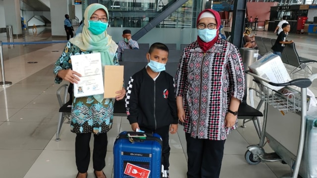 Pelaksana Fungsi Konsuler-4, Upi Dewi Marciana, mengantar pulang bocah berinisial MR yang ditelantarkan di Jeddah. Foto: KJRI Jeddah