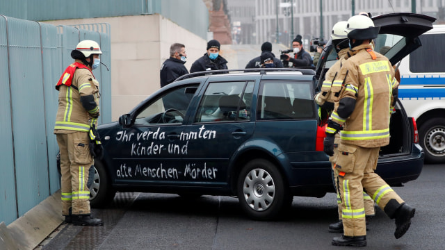 Petugas mengeluarkan mobil yang menabrak gerbang pintu masuk utama kanselir di Berlin, Jerman. Foto: Fabrizio Bensch/REUTERS