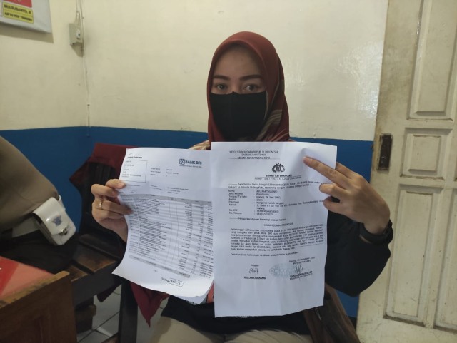Ayu Kartika Sari (35) menunjukkan bukti transfer rekening yang diembat pelaku dan surat laporan ke polisi terkait tindak penipuan dengan kode OTP yang dialaminya. Foto: Ulul Azmy
