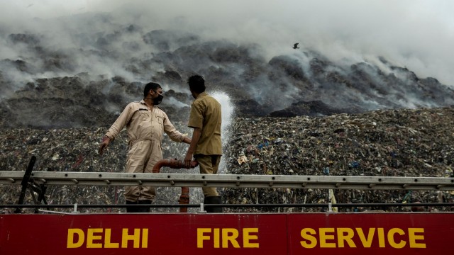 Petugas pemadam kebakaran mencoba memadamkan api saat asap mengepul dari pembakaran sampah di TPA Ghazipur, New Delhi, India, Rabu (25/11).  Foto: Danish Siddiqui/REUTERS