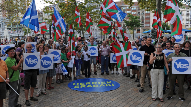 Orang-orang mengibarkan bendera Skotlandia untuk mendukung referendum Skotlandia pada 18 September 2014. Foto: RAFA RIVAS / AFP