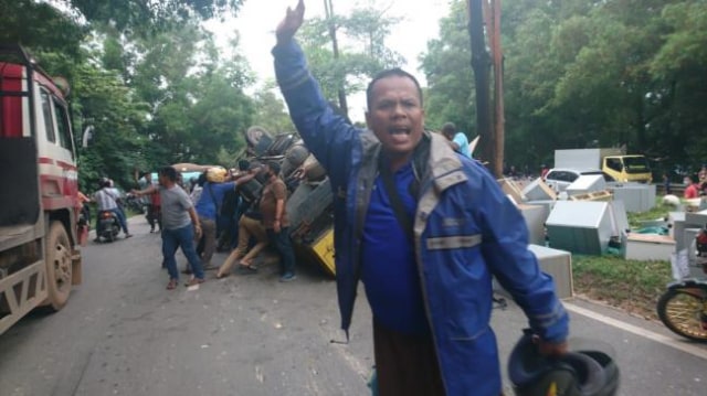 Warga saat menyelamatkan sopir truk yang terjepit di kabin pengemudi. (Foto: Reza/Batamnews).
