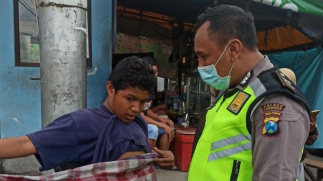 Bocah yatim piatu bernama Erlangga yang terlantar di Terminal Bojonegoro diselamatkan Aipda Purnomo.  Foto: dok. Istimewa